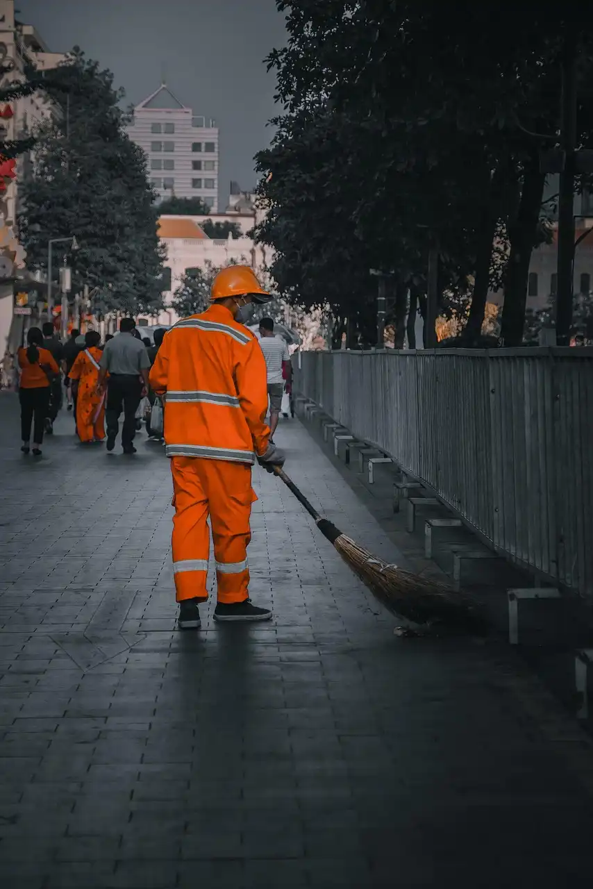 Trabajador de limpieza urbana con uniforme naranja durante su jornada laboral