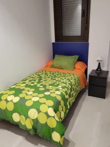 Habitación individual con cama y mesilla